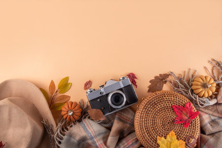 Fall seasonal walking leisure background with autumn leaves, sunflower flowers, cones, pumpkins, warm blanket, hat, knitted bag, photo camera. Comfortable autumn leisure backgroundの写真素材