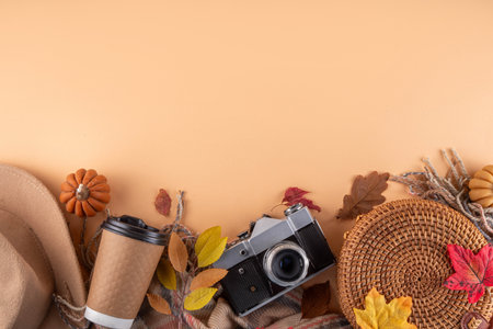 Fall seasonal walking leisure background with autumn leaves, sunflower flowers, cones, pumpkins, warm blanket, hat, knitted bag, coffee cup, photo camera. Comfortable autumn leisure backgroundの写真素材