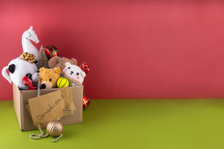 Donating gifts and toys to charity for Christmas holiday concept. Tradition holiday toys drive, cardboard box full with with kids toys, gifts, Christmas decorations, baubles and sweets, copy spaceの写真素材