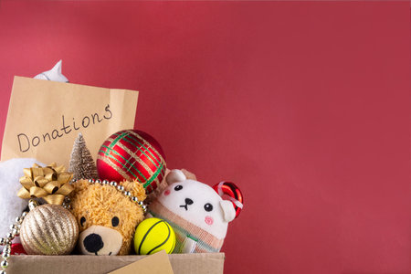 Donating gifts and toys to charity for Christmas holiday concept. Tradition holiday toys drive, cardboard box full with with kids toys, gifts, Christmas decorations, baubles and sweets, copy spaceの写真素材
