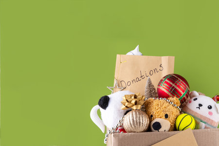Donating gifts and toys to charity for Christmas holiday concept. Tradition holiday toys drive, cardboard box full with with kids toys, gifts, Christmas decorations, baubles and sweets, copy spaceの写真素材
