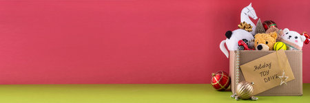 Donating gifts and toys to charity for Christmas holiday concept. Tradition holiday toys drive, cardboard box full with with kids toys, gifts, Christmas decorations, baubles and sweets, copy spaceの写真素材