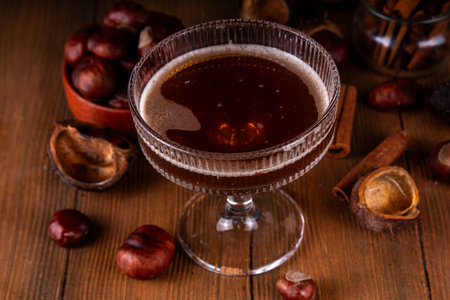 Strong alcohol chestnut martini cocktail, autumn dark and spicy alcoholic drink in martini glass with chestnut liquor and cinnamonの写真素材