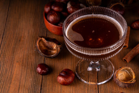Strong alcohol chestnut martini cocktail, autumn dark and spicy alcoholic drink in martini glass with chestnut liquor and cinnamonの写真素材