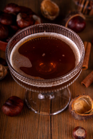 Strong alcohol chestnut martini cocktail, autumn dark and spicy alcoholic drink in martini glass with chestnut liquor and cinnamonの写真素材