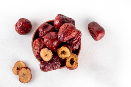 Bowl of dried red unabi or jujube berry fruits, healthy asian fruit, Chinese dates halfed and whole...