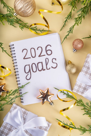 Notebook with New's Year Resolutions message, with Christmas ornaments and decor. New Year goals List 2026, plan listing of new year beginnings goals and resolutions setting. Flat lay copy spaceの写真素材