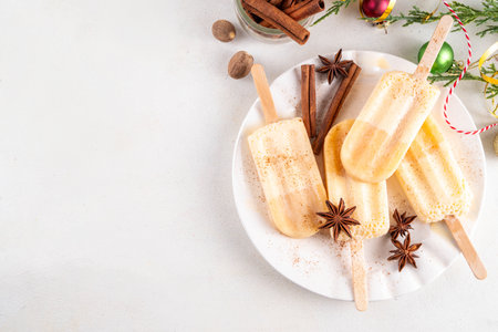 Christmas egg-nog ice-pops, ice cream popsicle with frozen eggnog. Non-alcohol winter gelato dessert, with whipped creamy texture, copy spaceの写真素材