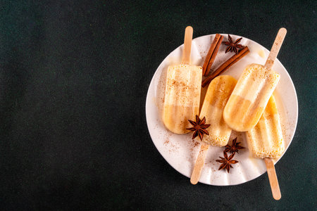 Christmas egg-nog ice-pops, ice cream popsicle with frozen eggnog cocktail. Alcohol or non-alcohol winter gelato dessert, with whipped creamy texture, copy spaceの写真素材