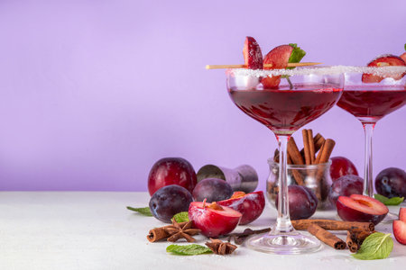 Sugar plum autumn winter sweet tasty drink. Alcohol or non-alcohol cocktail, mocktail with plum syrup, hard liqueur, spices, cinnamon and mint, copy spaceの写真素材