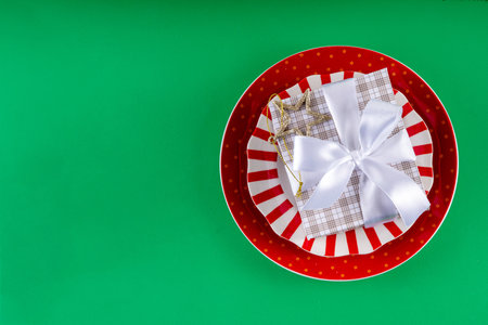 Christmas and New Year cutlery background, holiday table setting, festive dinner brunch invitation menu. Red white candy cane styled plate and Christmas baubles on bright green backgroundの写真素材