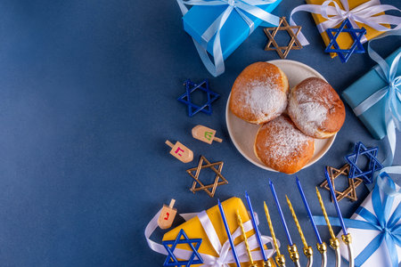 Happy Hanukkah greeting card background. Jewish New Year holiday flat lay with traditional symbols of hanukkah festival, menorah with festive candles, donuts and decorations copy spaceの写真素材