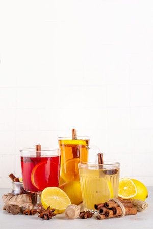 Three different Hot Toddy drinks in different tea cups - hot autumn winter tea cocktail beverages with scotch, rum and mezcal alcohol drinks, spices, lemon and honeyの写真素材