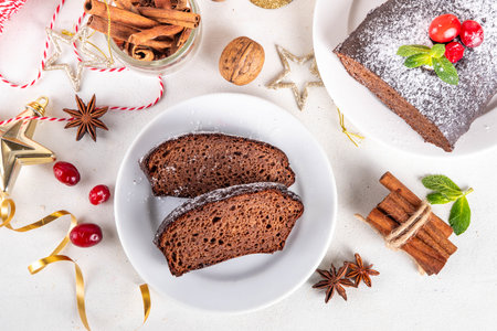 Homemade gingerbread loaf cake. Freshly baked Christmas Gingerbread chocolate cake with sugar powder topping, on white festive decorated backgroundの写真素材