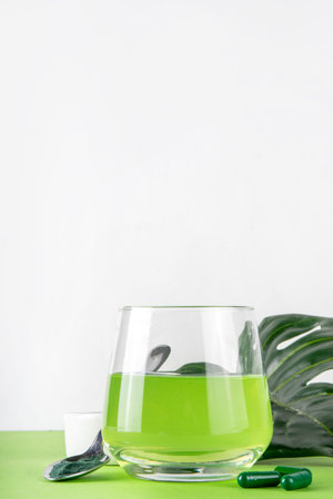 Liquid Chlorophyll Drink. Bottle and Glass with Green Chlorophyll Water, Chlorophyll powder and...