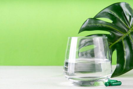 Liquid Chlorophyll Drink. Bottle and Glass with Green Chlorophyll Water, Chlorophyll powder and pills, healthy trendy vitamin beverageの写真素材