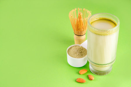 Matcha powder protein drink, vegan matcha tea protein whey shake cocktail, with almond.Healthy vegetarian superfood, trendy diet beverage, with protein powder in scoop, on white green backgroundの写真素材
