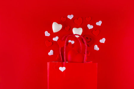 Valentine day sale and shopping background . Red paper shopping bag with text sale, white, red, gold hearts. Simple minimal Valentines greeting card, invitation, marketing promo mockup copy spaceの写真素材