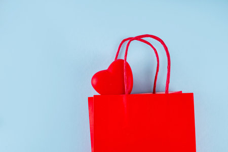 Valentine day sale and shopping background . Red paper shopping bag with text sale, white, red, gold hearts. Simple minimal Valentines greeting card, invitation, marketing promo mockup copy spaceの写真素材