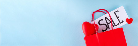 Valentine day sale and shopping background . Red paper shopping bag with text sale, white, red, gold hearts. Simple minimal Valentines greeting card, invitation, marketing promo mockup copy spaceの写真素材