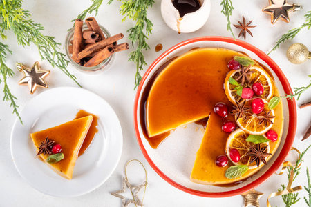 Traditional Mexican Christmas food  - caramel Eggnog Flan cake, Festive Christmas Custard Tart or Flan Topped with Caramel sauce, candied orange and cranberry, with Christmas decor copy spaceの写真素材