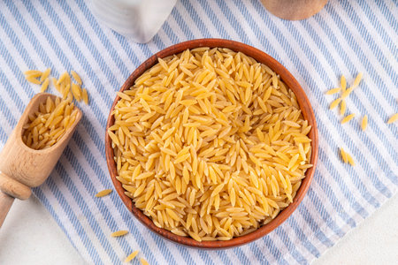 Raw uncooked orzo pasta, Italian dry pasta risoni orzo in bowl on table, copy spaceの写真素材