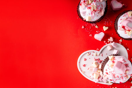 Valentine day tasty double chocolate cupcakes treat with whipped cream, heart shaped marshmallow and sugar sprinklesの写真素材