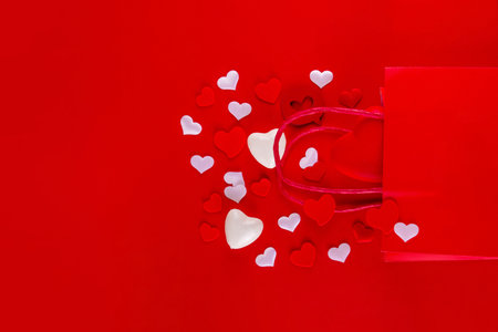 Valentine day sale and shopping background . Red paper shopping bag with text sale, white, red, gold hearts. Simple minimal Valentines greeting card, invitation, marketing promo mockup copy spaceの写真素材