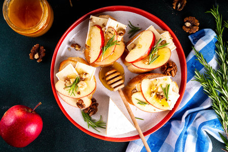 Autumn Apple Brie Crostini with Walnuts and Honey, Fall dinner, Thanksgiving party appetizers idea. Small sandwiches with red apple slices, brie cheese and sweet honey drizzlesの写真素材