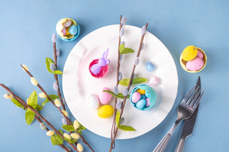 Spring Easter holiday menu table setting, cutlery and plate on pastel blue background with checkered...
