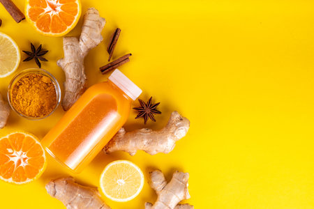 Ginger turmeric immunity shot, tasty vitamin citrus fruit infused drink in small bottles, made with orange, lemon, turmeric, ginger, cinnamon, spices, alternative medicine flu and cold remedy beverageの写真素材