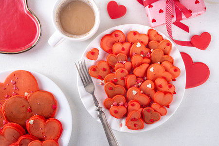 Sweet cute sign of love on Valentine's Day, lovely breakfast, snack with red velvet pancakes in form of hearts, with sugar sprinkled hearts and berry. Simple food idea for Valentine's Day surprise giftの写真素材