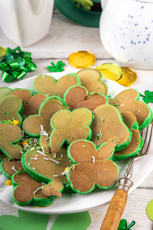 Shamrock shaped green tasty sweet pancakes for St Patricks day breakfast. Creative homemade tasty fried pan cakes with sugar sprinkles and Saint Patrick holiday decorの写真素材