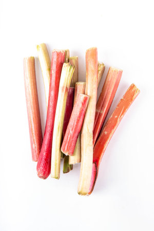 Raw fresh organic rhubarb stems on white background, bunch of homegrown pink and green rhubarb ready...