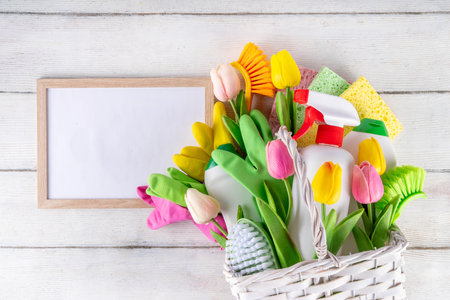 Spring cleaning background with spring flowers and cleaning utensils in white basket, Various household supplies, bottles, accessories, with blossom tulips, spring cleaning sale promotion copy spaceの写真素材