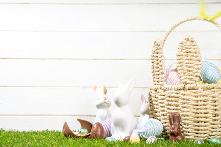 Easter egg hunting background. Easter basket with colorful Easter egg, chocolate eggs, bunny and...