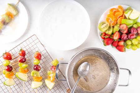 Traditional Chinese sweet street food recipe Tanghulu, fruit skewer on stick with crunchy sugar glaze, easy healthy dessert. Step by step preparation of Tanghulu with ingredients on table, top viewの写真素材