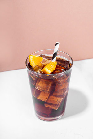 Cold summer drink with cola, dark rum, orange and crushed ice, with bar utensils and shaker, copy...