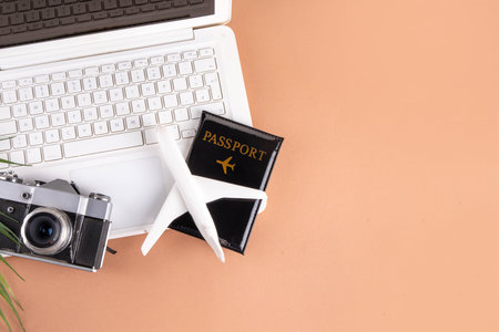 Summer work and travel background, white laptop with documents, ticket, airplane and photo camera on...
