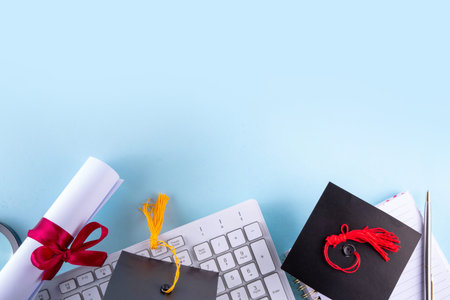Happy graduation day background. Graduation themed accessories - rolled diploma with red ribbon, graduation cap, books and notebook for preparing for exams, keyboard, eyeglasses and pen