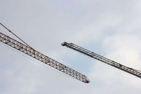 Two lifting cranes against the skyの写真素材