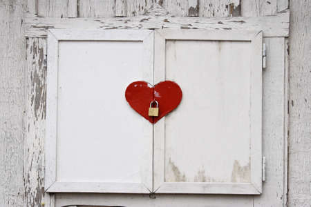 window shutters in heart shape with a lockerの写真素材