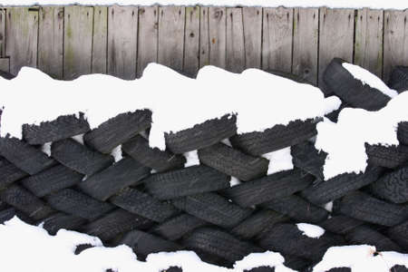 A lot of  tyres against a barn wallの写真素材