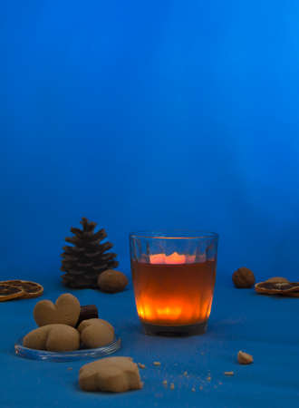 cup of tea with lemon on a blue background night book cookie candle heartの写真素材
