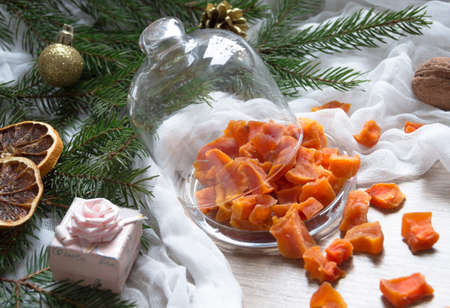 dried fruit pumpkin pineapple orange candied fruits on a table under a glass cap cap christmas tree bumps clothの写真素材
