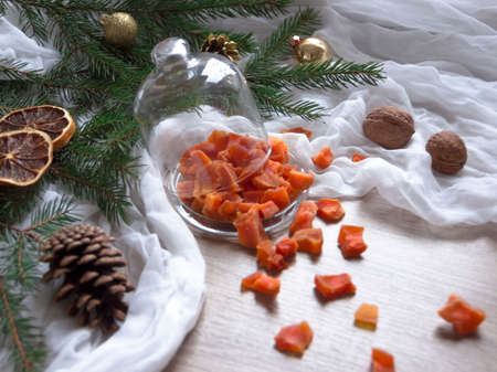 dried fruit pumpkin pineapple orange candied fruits on a table under a glass cap cap christmas tree bumps clothの写真素材