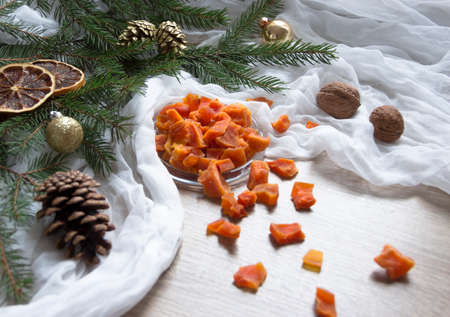 dried fruit pumpkin pineapple orange candied fruits on a table under a glass cap cap christmas tree bumps clothの写真素材