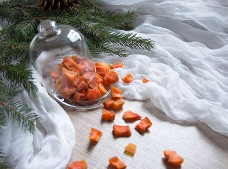 dried fruit pumpkin pineapple orange candied fruits on a table under a glass cap cap christmas tree bumps clothの写真素材