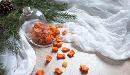 dried fruit pumpkin pineapple orange candied fruits on a table under a glass cap christmas tree bumps clothの写真素材
