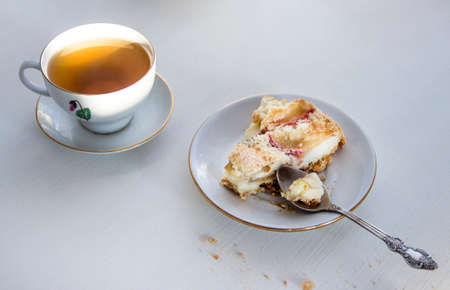 cup of tea and plate with apple pie on white tableの写真素材